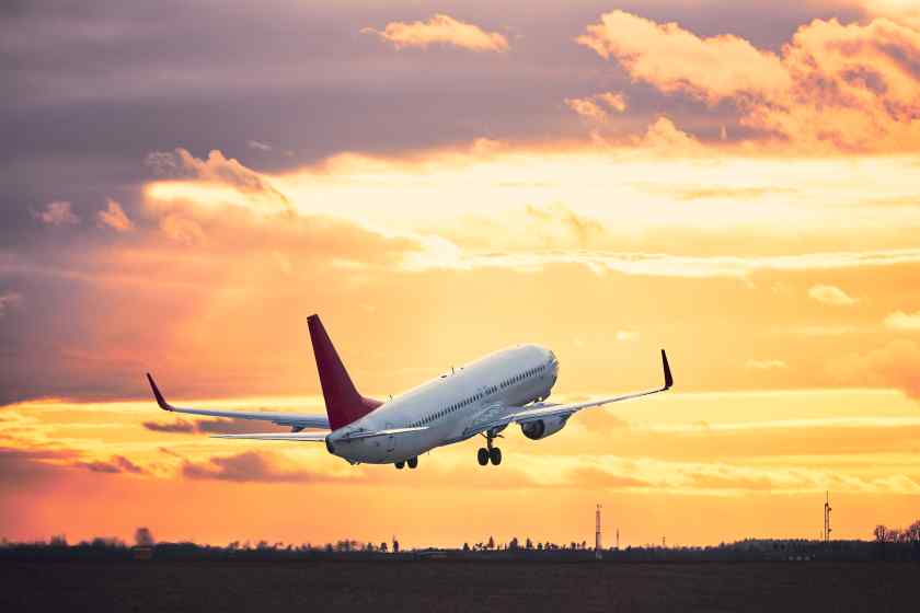 Airplane-flying-runway-against-sky-sunset - travel and tour world