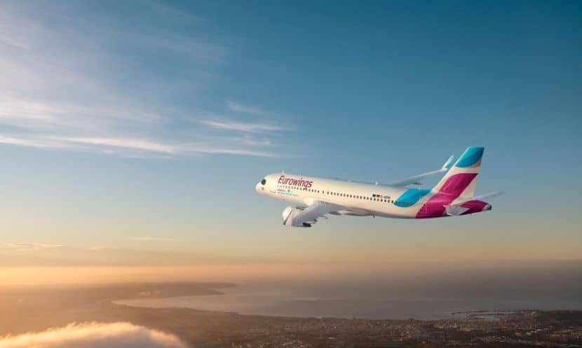 Eurowings airplane flying over clouds in the sky.
