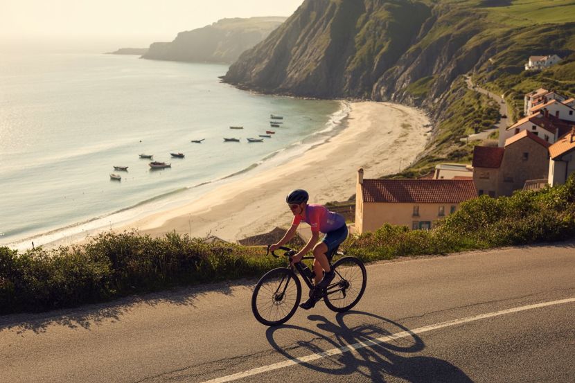 Cyclist riding along coastal road - travel and tour world Cycling routes