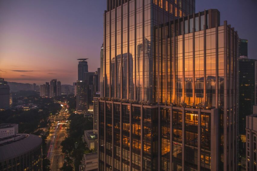 Luxury kuala lumpur hotel at sunset with city skyline view.