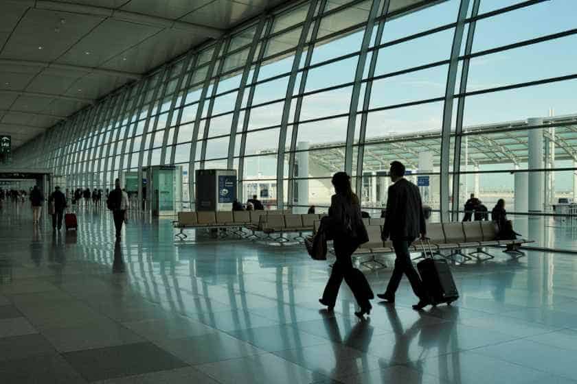 Modern airport terminal with travelers and luggage.