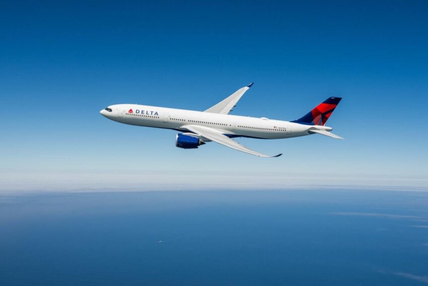 Delta airlines commercial airplane flying high in clear blue sky.