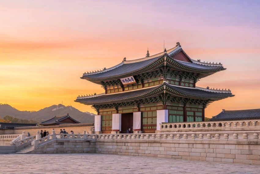 Ancient korean palace at sunset with traditional architecture and scenic mountai.