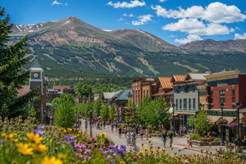 Breckenridge summer tourism recovery in colorado - travel and tour world Sunny breckenridge mountain town in colorado with summer visitors, colourful streets, flowers and rocky mountain views.