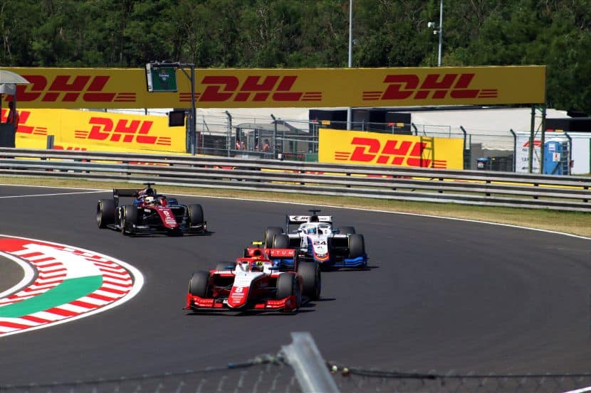 Grand prix - travel and tour world A panoramic view of the red bull ring circuit nestled within the scenic, mountainous landscape of the styrian region in austria, featuring vibrant grandstands and the surrounding green hills during an f1 austrian grand prix race weekend.