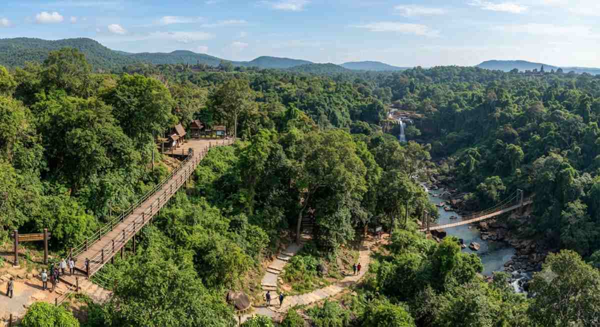 A wide view of the lush, forested hills of phnom kulen national park, highlighting the natural beauty and ongoing infrastructure improvements aimed at promoting sustainable tourism in cambodia.