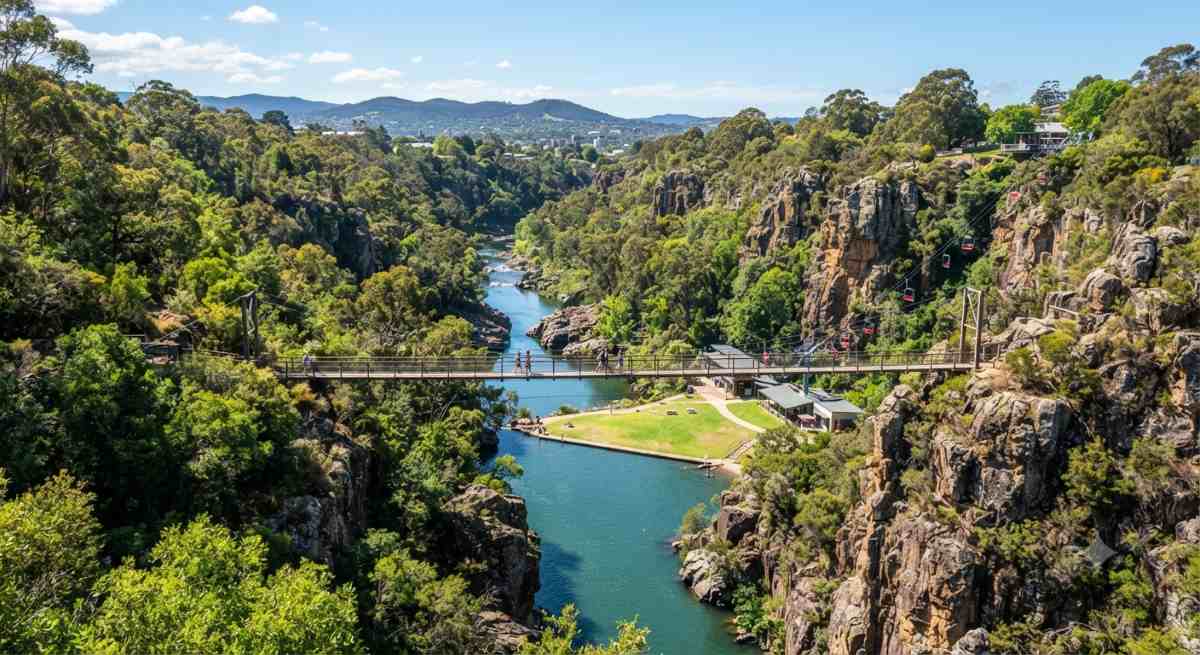 Launceston - travel and tour world A scenic view of the cataract gorge in launceston, australia, showing the lush river valley, the suspension bridge, and the rugged cliffs that attract nature lovers.