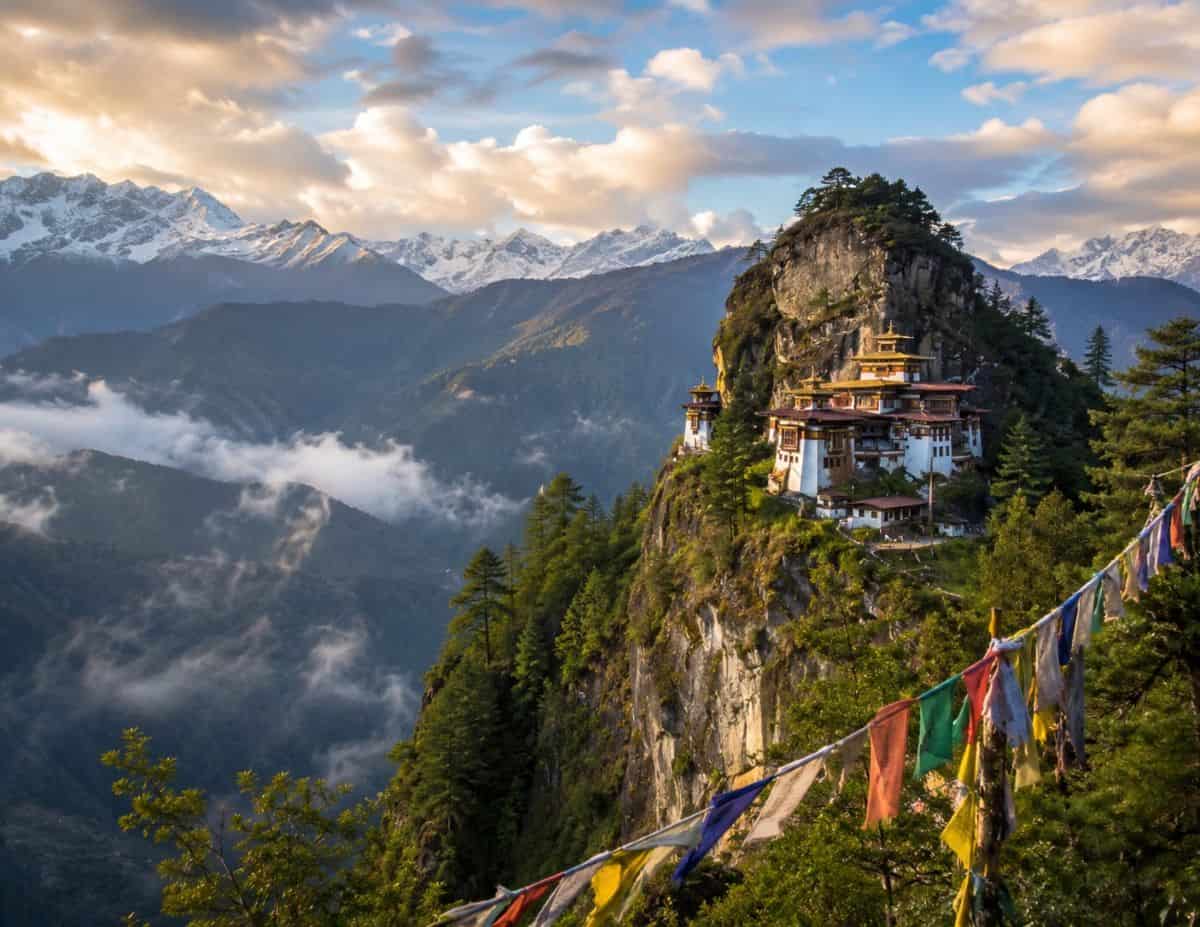 Bhutans majestic tiger hill with misty himalayan mountains lush valleys and a serene cliffside monastery under golden skies - travel and tour world Bhutan’s majestic tiger hill with misty himalayan mountains, lush valleys, and a serene cliffside monastery under golden skies.