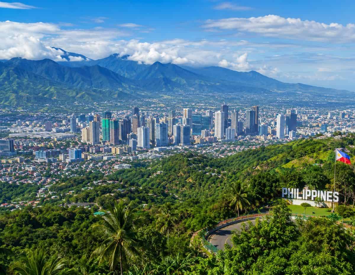 Philippines panoramic cityscape surrounded by lush mountain valleys, tropical greenery, modern skyline, and breathtaking natural scenery.