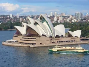 Sydney opera house overlooking sydney harbour in australia under a clear blue sky.