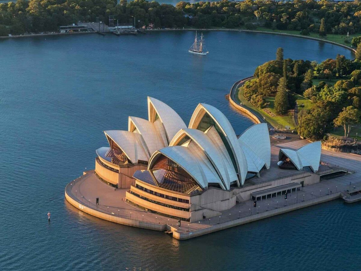 Sydney opera house overlooking sydney harbour in australia under a clear blue sky.