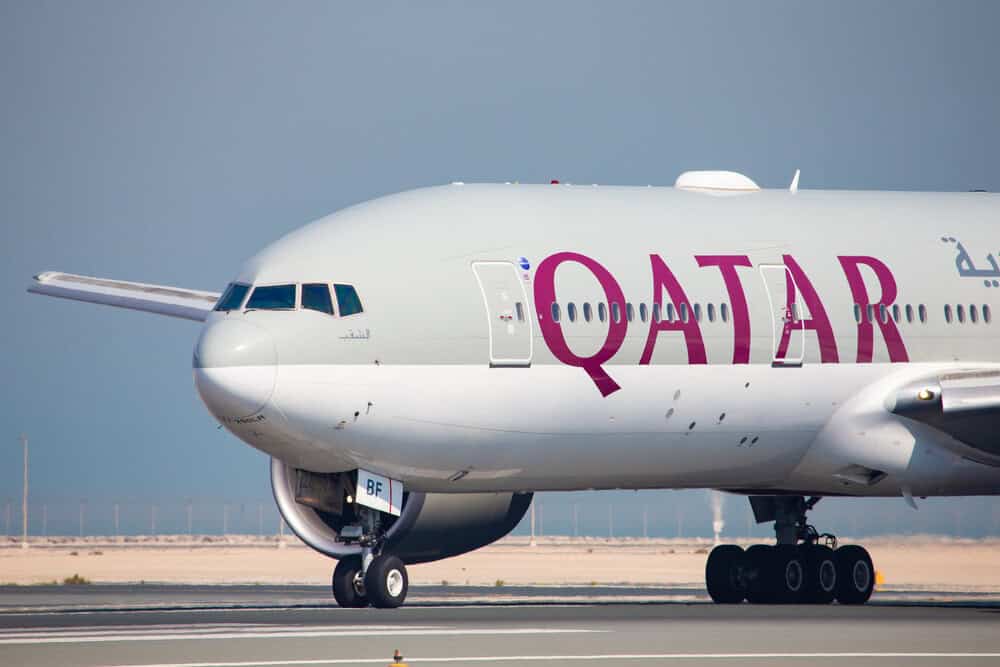 Qatar airways aircraft at airport terminal promoting international flight sale discounts for europe and global destinations