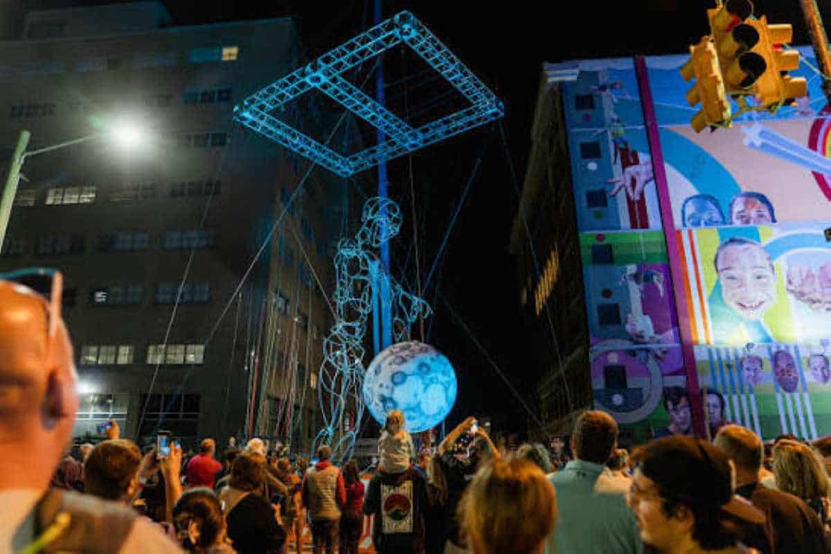 An enormous modern sculpture displayed prominently in a public park in grand rapids during the artprize festival.