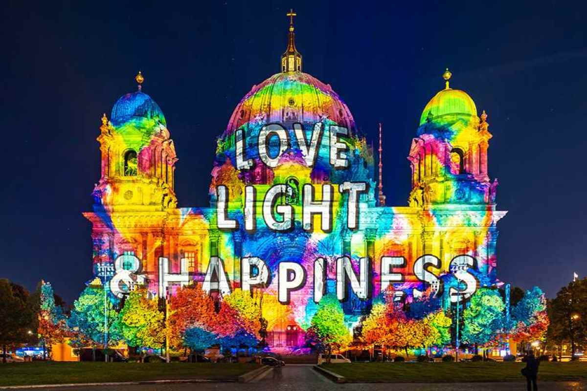 A vibrant night view of the berlin cathedral illuminated with colorful 3d light projections and patterns during the annual festival of lights in berlin, germany.