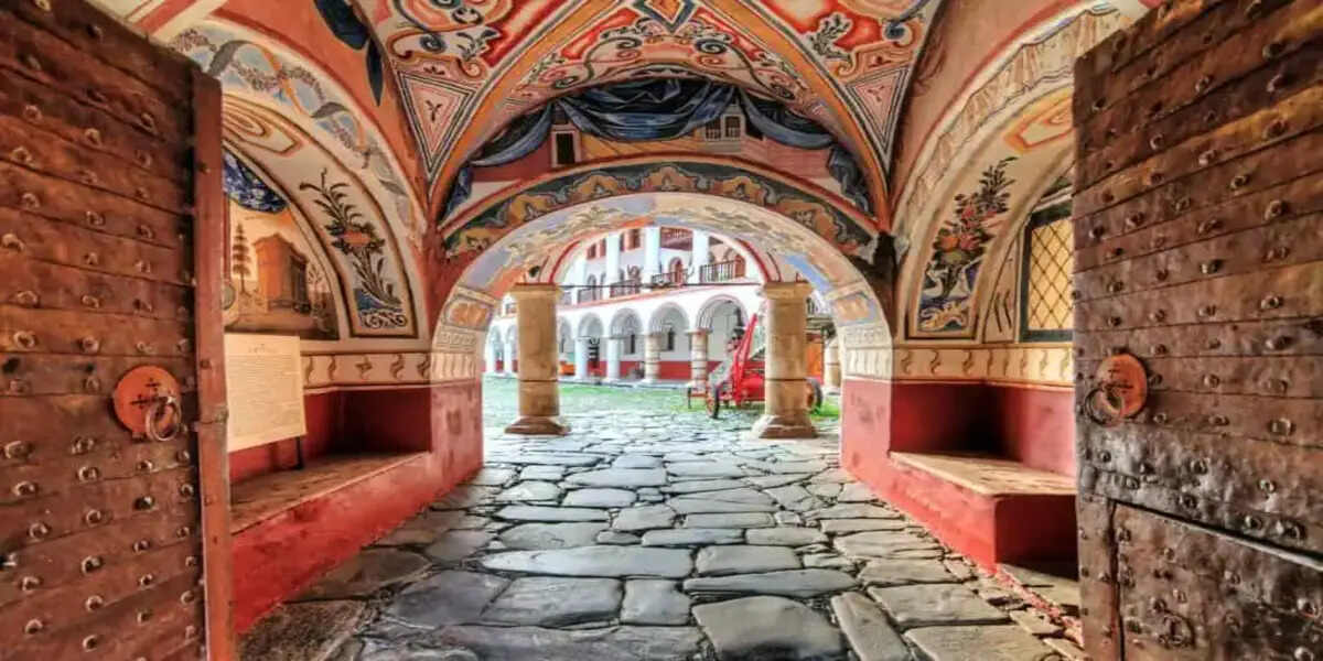 Ancient bulgarian monastery entrance with traditional frescoes and historic stone courtyard