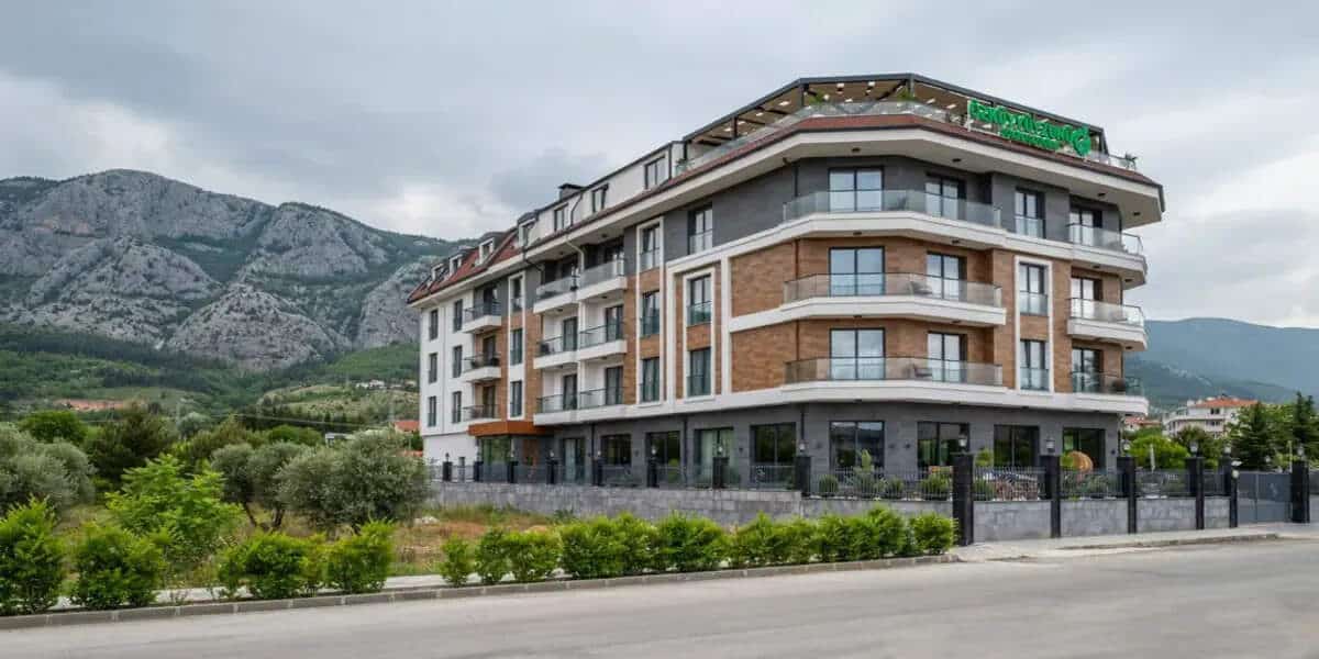 Wyndham garden antalya konyaaltı hotel building surrounded by mountains and greenery