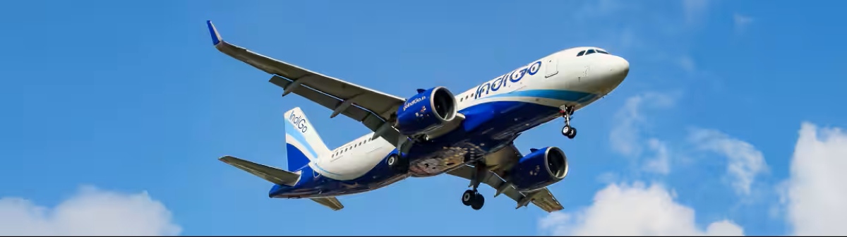 A commercial aircraft operated by indigo parked on an airport tarmac during daytime operations.