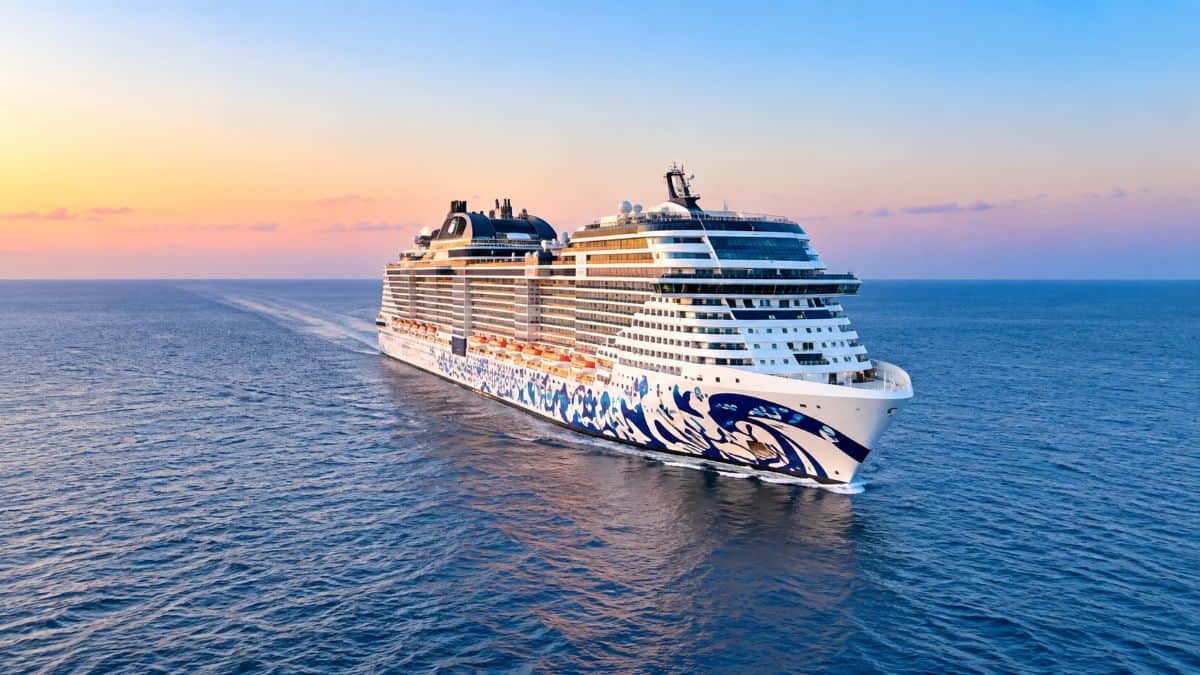 Luxury cruise ship sailing through blue ocean waters under a bright sky, representing MSC Cruises’ expanded winter 2027-28 global deployment.
