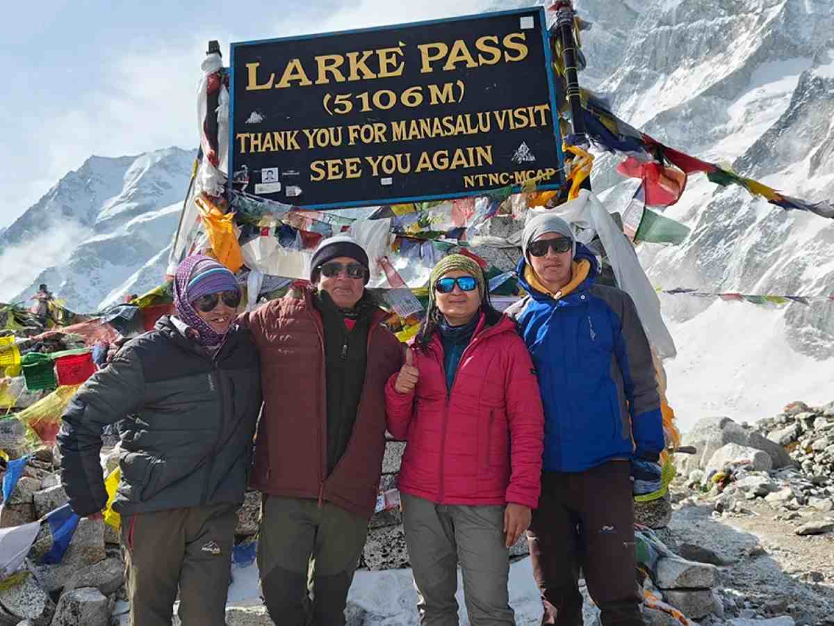Manaslu - travel and tour world A panoramic view of mount manaslu base camp in the himalayas, featuring expedition tents set against a towering snow-capped peak during the autumn climbing season.