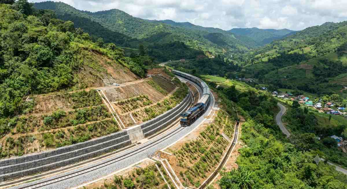 A view of railway tracks passing through a green hilly terrain in mizoram, depicting restored connectivity after landslide repairs.