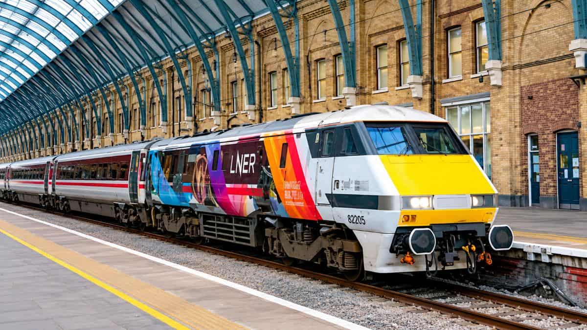 Passengers travelling through a busy UK railway station as modern trains operate under new cross-operator ticket rules.
