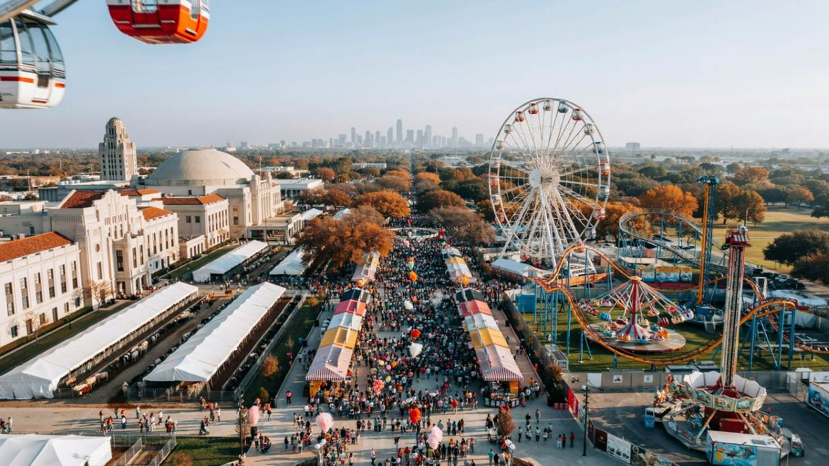 The iconic big tex logo framed in front of the giant texas star ferris wheel at fair park in dallas
