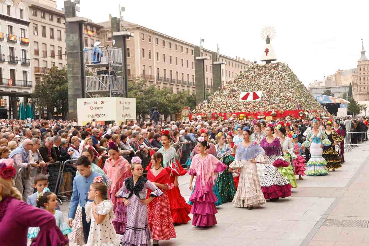 Zaragoza - travel and tour world Thousands of people in traditional aragon attire gathered in the bustling plaza del pilar during the vibrant fiestas del pilar celebration in zaragoza.
