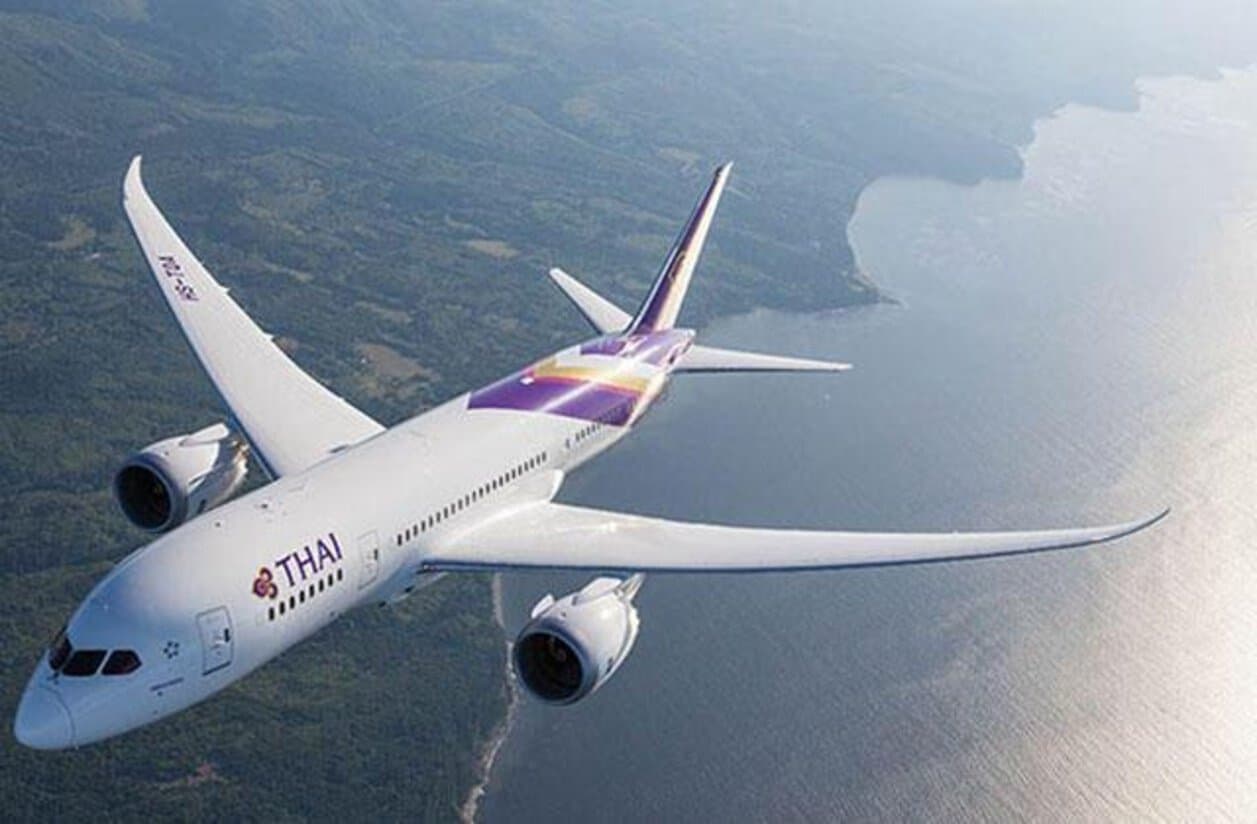 Airlines - travel and tour world Thai airways boeing 787 dreamliner flying above thailand’s coastline.