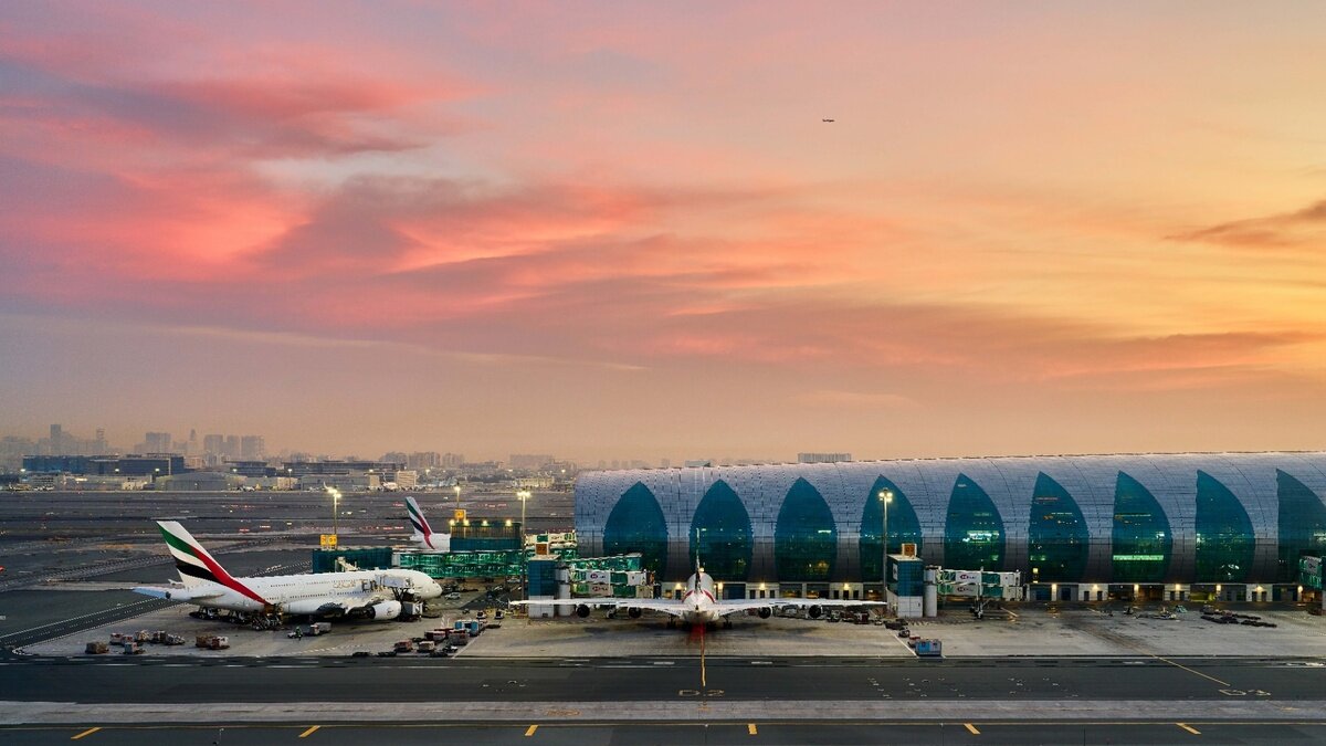 Dubai international airport terminal and aircraft at sunset.