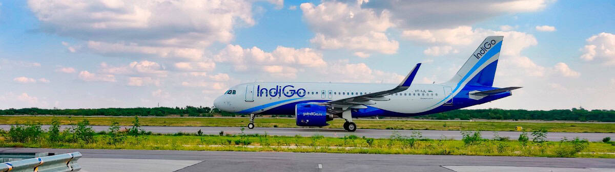 Indigo - travel and tour world Lndigo passenger aircraft at an airport, illustrating the planned transfer of 12 daily international departures from mumbai to navi mumbai in february 2027.