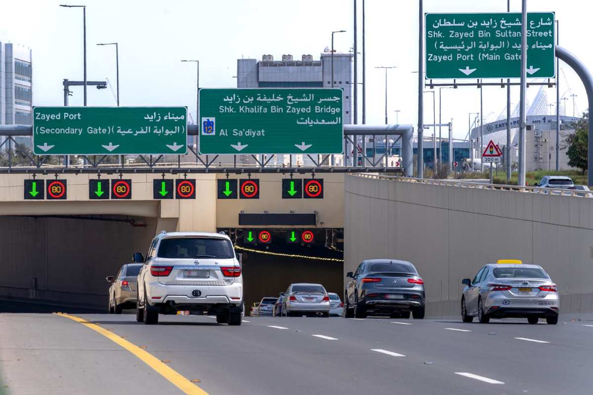 Abu dhabi - travel and tour world A wide-angle exterior view of abu dhabi mina tunnel entrance showing smooth traffic flow under clear daytime skies.