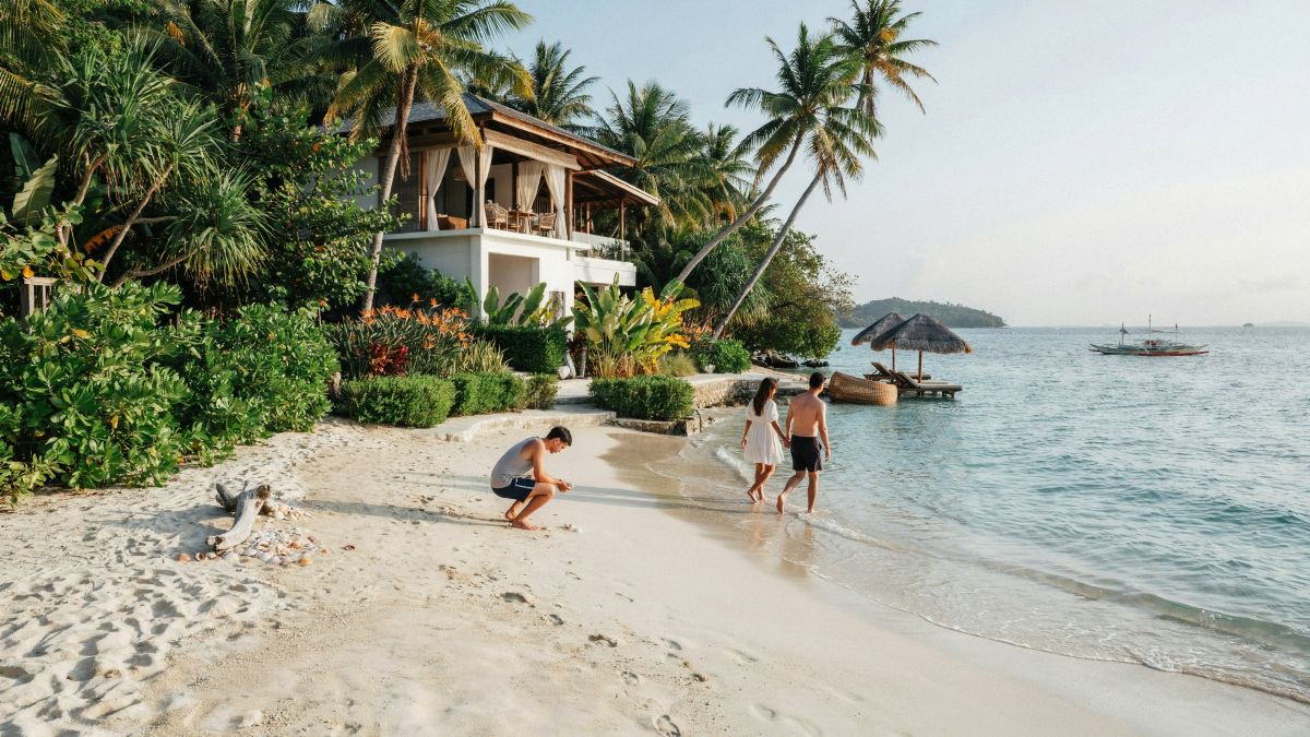 Boracay&rsquo;s white-sand shore with a resort set among tropical greenery.