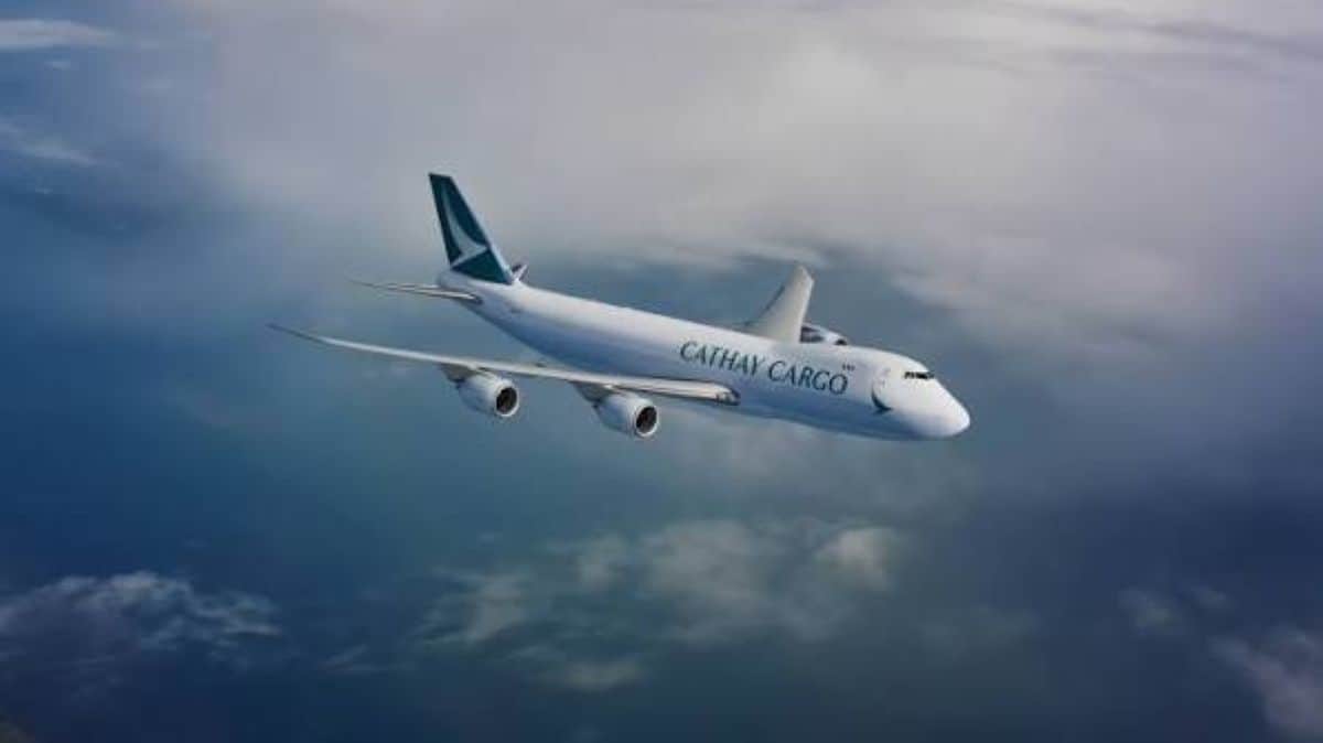 Cathay pacific - travel and tour world Cathay pacific cargo aircraft flying above clouds during flight.