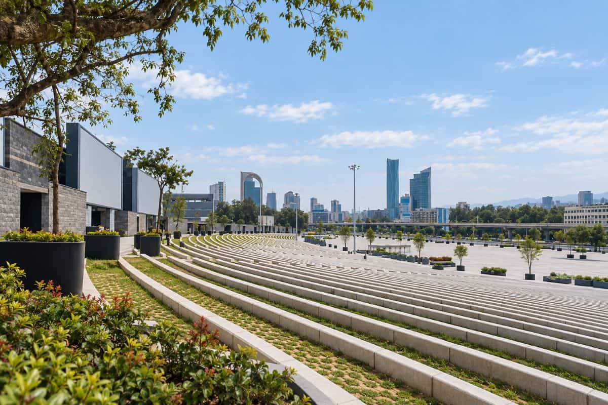 View of meskel square in addis ababa, ethiopia, with curved terraces, trees and the city skyline in daylight.