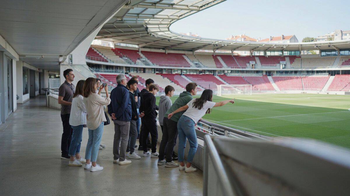 European football tourism - travel and tour world Visitors take a guided tour of a portuguese football stadium and look across the pitch.