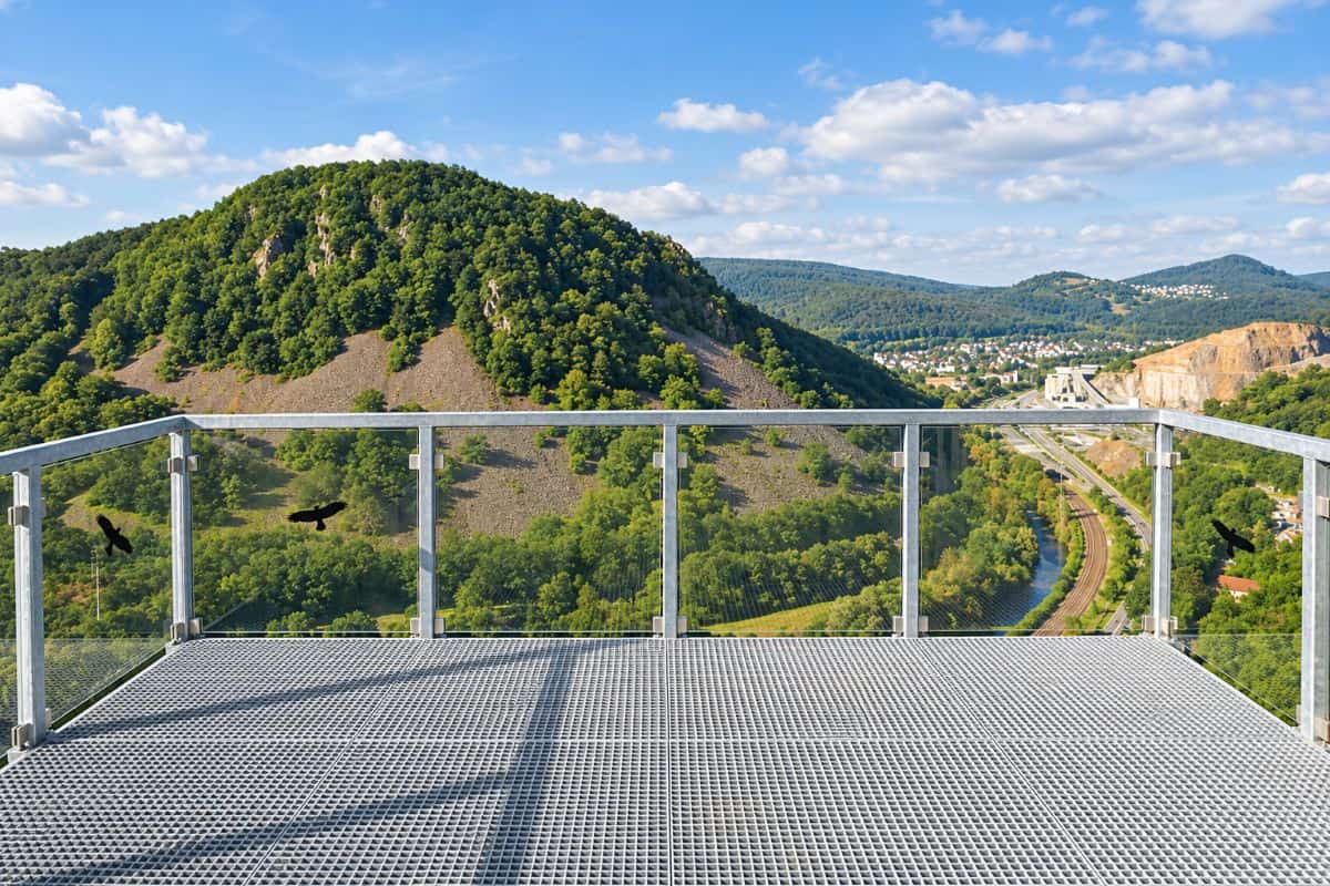 Germany is promoting skywalk tourism in hunsrück with great views and more to see on the trails - travel and tour world Empty nahe-skywalk platform with glass railings overlooking wooded hills and the nahe valley in germany.
