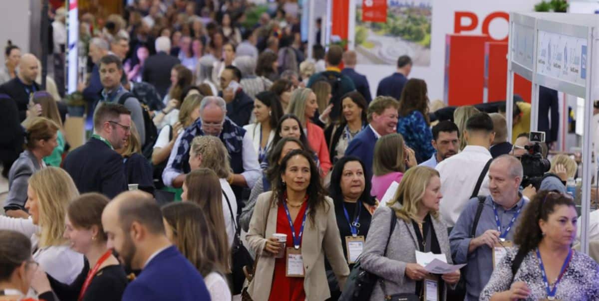 Conference attendees talk and browse destination booths at a busy imex america trade show in las vegas.
