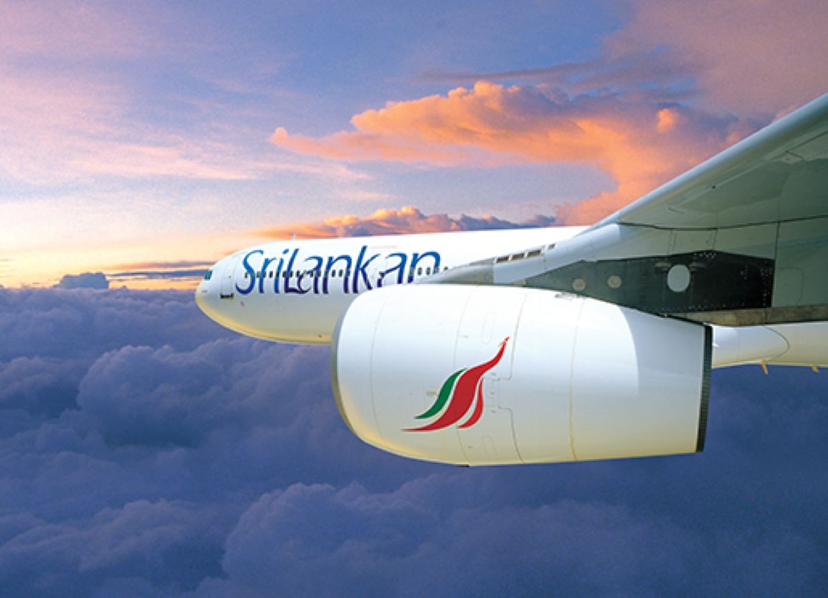 Srilankan airlines aircraft flying above clouds at sunset.