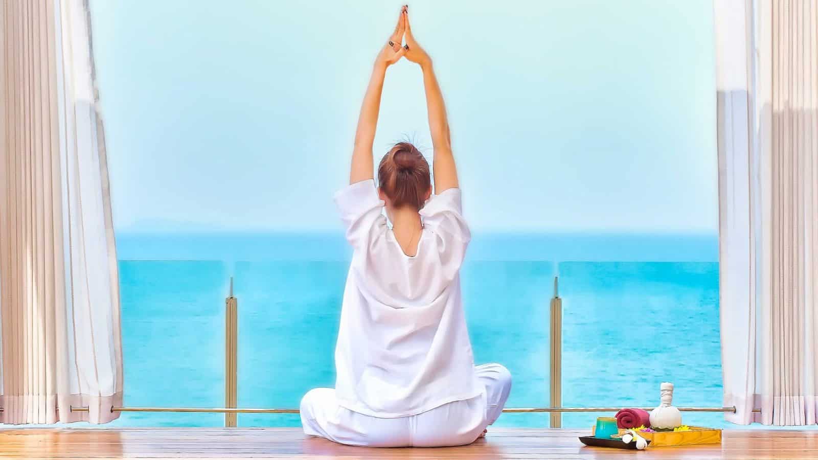 Phuket wellness tourism 2026 - travel and tour world Woman practising yoga overlooking turquoise sea in phuket, thailand.