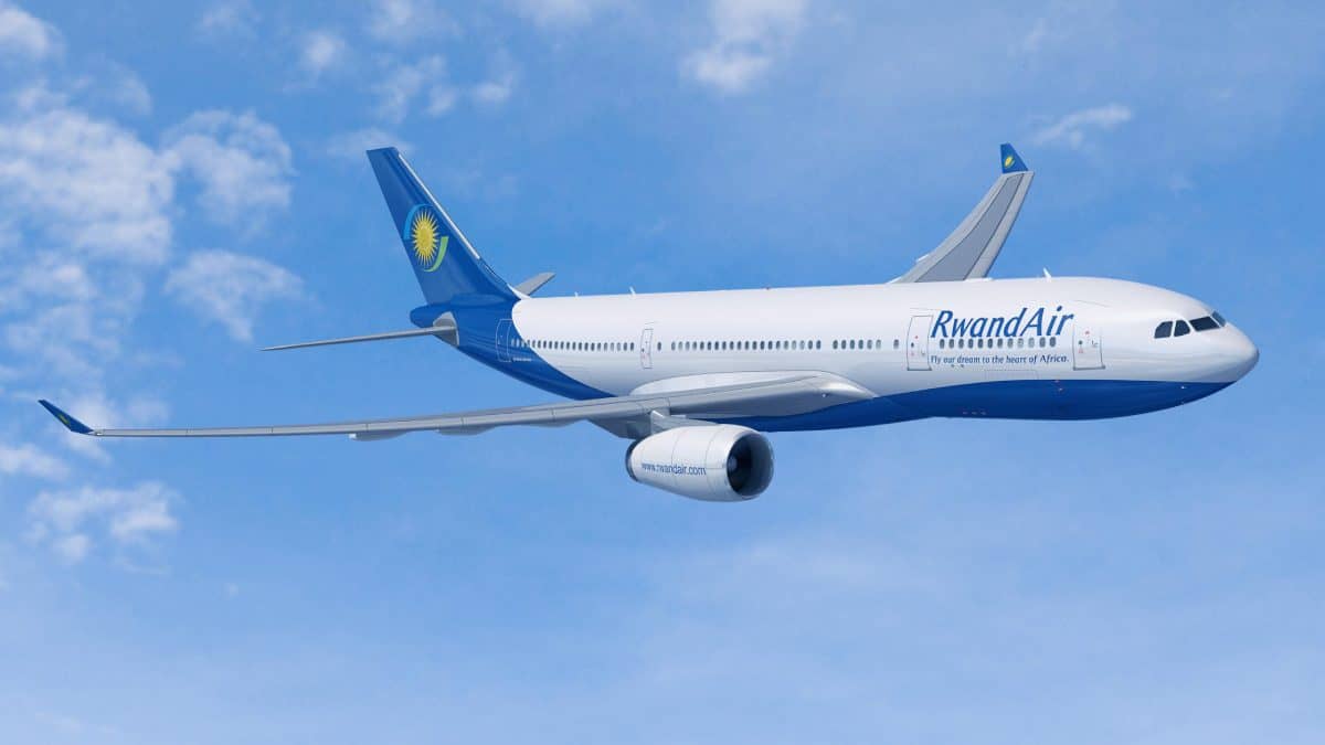Airspace disruptions - travel and tour world A wide-body rwandair airbus passenger aircraft cruises through a clear blue sky with scattered light clouds.