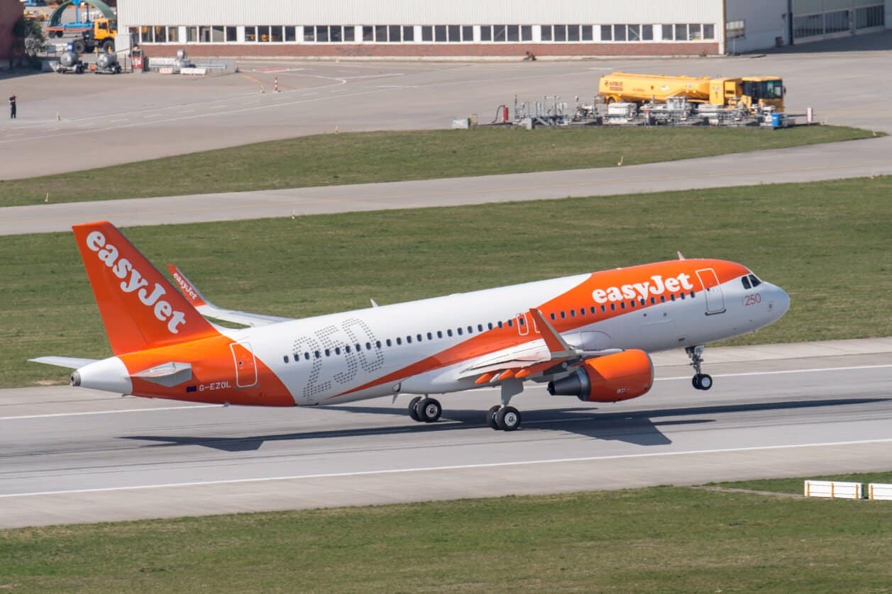 Easyjet aircraft taking off with its nose wheel raised and main wheels on the runway.