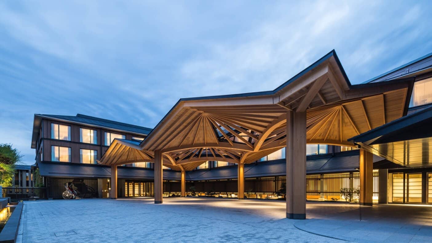 Four-seasons-hotel-kyoto-tenth-anniversary-luxury-hotel-japan - travel and tour world Four seasons hotel kyoto luxury entrance featuring traditional japanese wooden architecture and elegant evening lighting in japan.