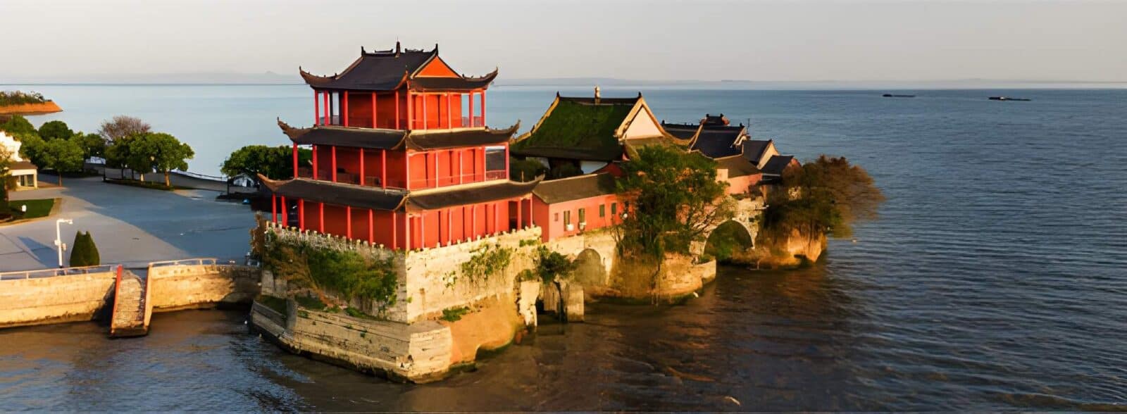 Hk express hefei promotional banner featuring waterfront architecture, an illuminated building and a passenger aircraft.