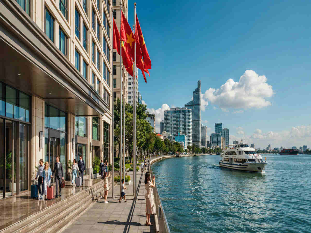 Vietnam tourism and european investment opportunities - travel and tour world Tourists and business travellers along ho chi minh city's waterfront in Vietnam.