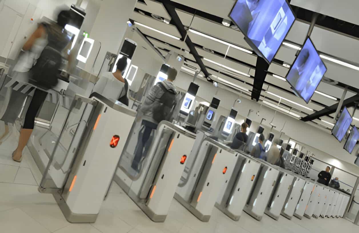 Automated passport gates beneath uk border signage.